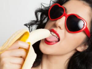 Femme avec lunette de soleil léchant une banane lovatoy